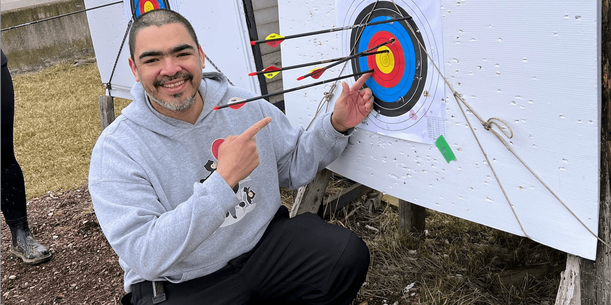 Jorge Vergara pointing at a target showing an arrow in the bullseye